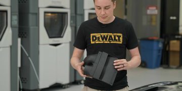 מהנדס בוחן חלק מודפס עבור מכונית המירוץ. באדיבות סטרטסיס