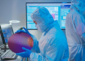 מהנדס IC מחזיק ביד פרוסת שבבים לאחר ייצור. איור יחצ