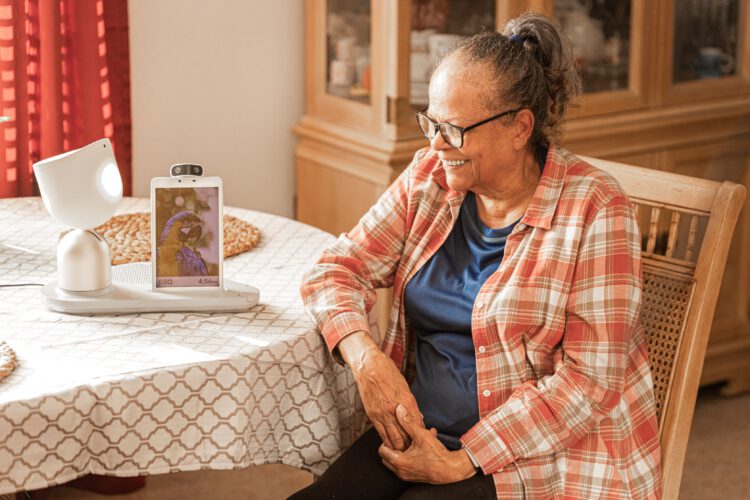 הרובוט ElliQ והקשישה אניטה מונטסגו. צילום: Intuition Robotics